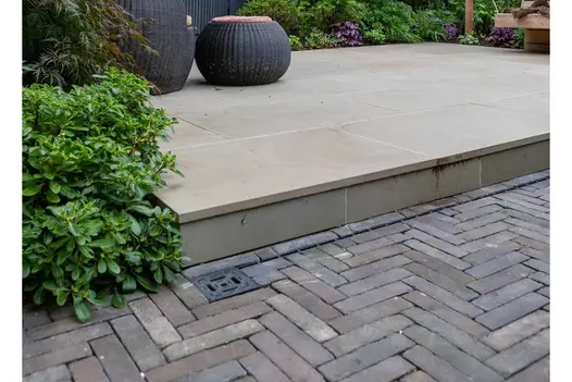 Raised patio of Heath sawn sandstone with step down to Ancona clay brick paving. Design by Daniel Shea. Built by Acacia Gardens.