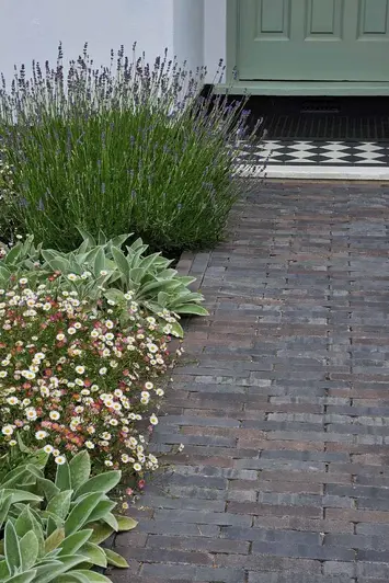 View up path created with Ancona Clay Pavers leads to front door with flowerbed running up the left hand side.