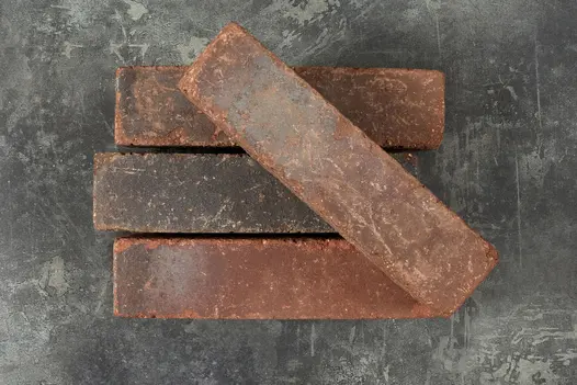 3 Carbona grey clay pavers, with 4th brick laid at angle on top, showing red and black colours. Free UK next-day delivery available.