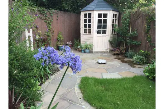 Path edged with Autumn Brown sandstone setts leads to paving circle and white octagonal summer house. Design by Floral and Hardy.
