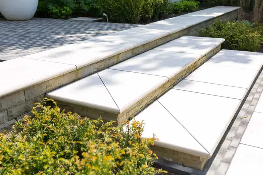 2 Florence White bullnose porcelain steps laid with different shaped slabs for decorative effect. Design by Barnes Walker.