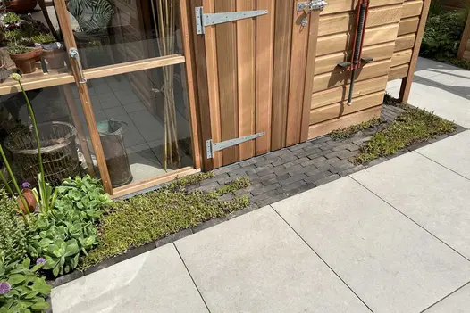 Strip of Lucca Clay pavers and low growing plants, runs along base of Gabriel Ash garden shed. Built by Base Squared.