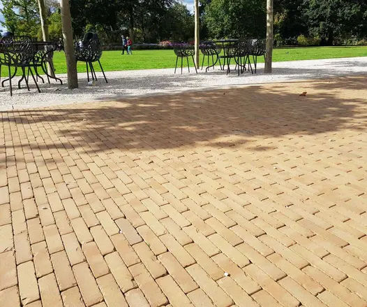 Large public lawn separated from Westminster brick paved area by gravel strip with chairs and tables. Built by Blakedown Landscapes.