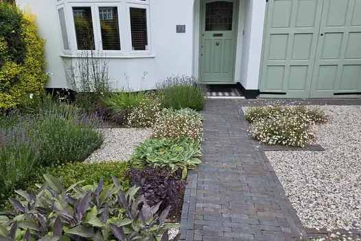 Path to front door of ancona clay pavers creates unique design with insets of the dutch clay pavers to make flowerbeds.