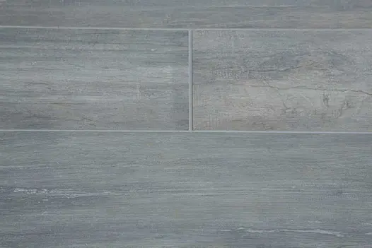 Cinder wood effect porcelain pavers grouted with dark grey grout showing distinctive texture of the material.