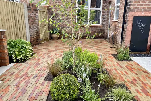Side of house paved with mixed Seville and Westminster Clay Pavers with square-angled beds inset. Laid by Bark Brick & Block.