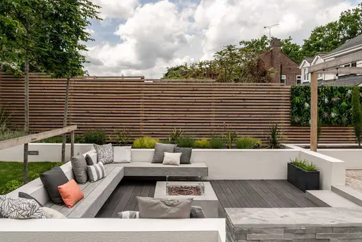 Square seating area enclosed by low walls, with built-in benches in DesignBoard Luna composite decking around 3 sides of fire pit.