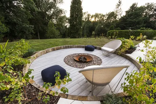 Circled area using luna designboard composite decking has steel corten fire pit in the middle with views of large, private lawn.
