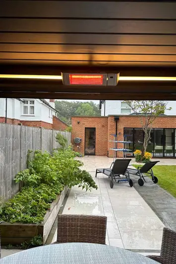 Deluxe Anthracite Grey 3x3 Metal Pergola in a landscaped garden, with heater for year-round comfort.