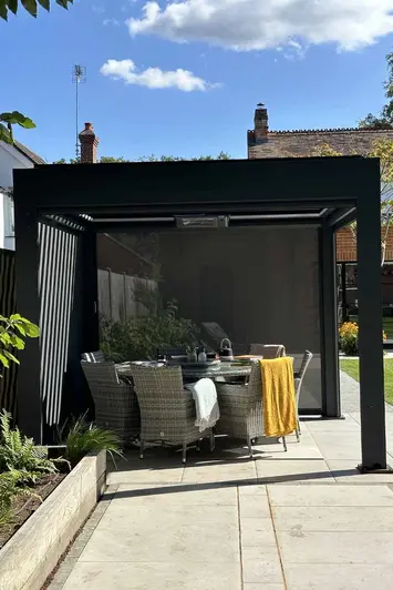 Detailed shot of the Deluxe Anthracite Grey 3x3 Metal Pergola with one side blind down and the louvres open.