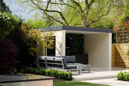 Porcelain paving patio with composite pergola clad in desert beige porcelain cladding with bar and lounge area.