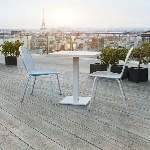 2 chairs and table on roof top in Paris with view of Eiffel Tower, completed decked in Driftwood grey Millboard.