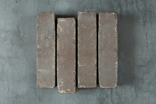 4 Lugano Clay Pavers, set on edge against grey background, showing even colour and tumbled edges. Free next-day delivery available.