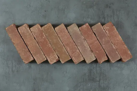 Nine Roma Clay pavers laid on their side on dark background, showing colour and texture. Free UK delivery available.