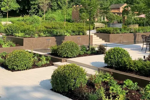 Multi-level garden with dining area and raised garden bed, large clad built-in planters and Faro Porcelain 36mm Bullnose Steps.