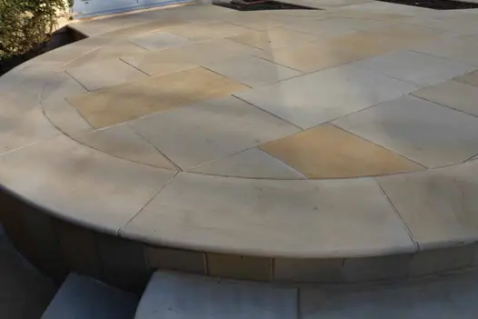 Circular cuts of harvest smooth sandstone paving and bullnose steps show off multiple tones and shadows. By John Gale.