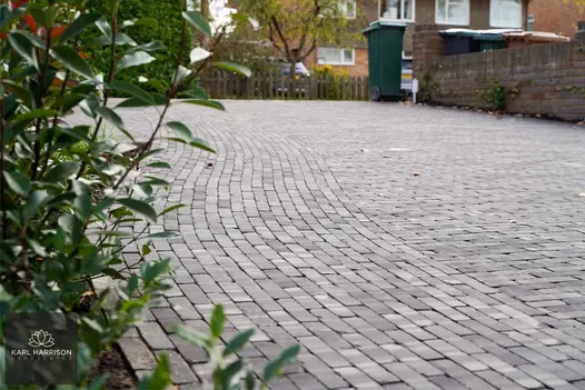 Deep house frontage sloping towards viewer, paved entirely in dark grey Lucca clay pavers. Design by Karl Harrison.