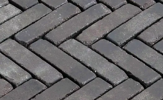 Close-up of Lucca brick paving laid herringbone, showing dark tones when wet. Free next-day UK delivery available.