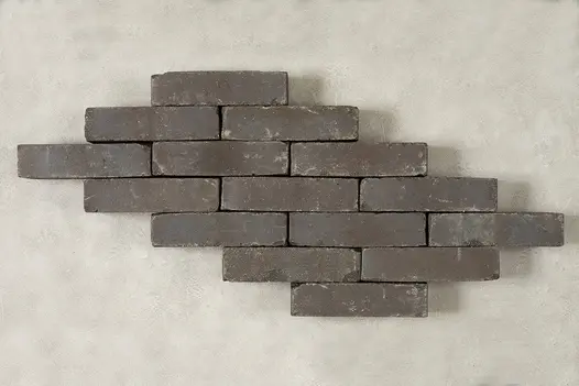 15 Lugano clay pavers arranged in graduated rows of 3, 2 and 1 bricks to create skewed lozenge shape against pale background.