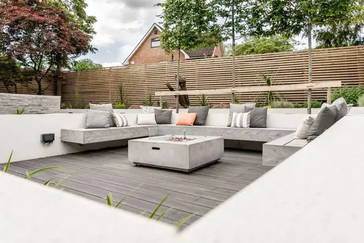 3 pleached trees behind square seating area with built-in benches and Luna DesignBoard composite deck. Built by Gadsden Gardens.