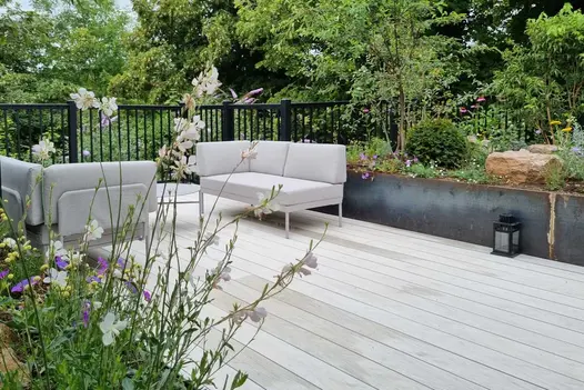 Grey modular furniture on Luna DesignBoard composite deck. Planted beds with boulders behind. Design by Adam Vetere. Built by JJH.