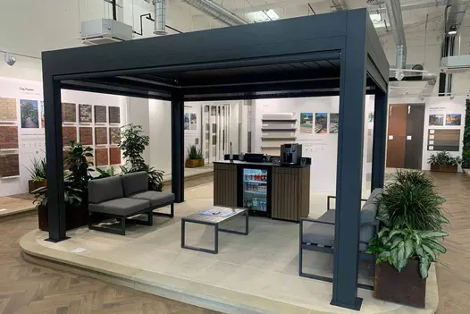 A side view of the Deluxe Anthracite Grey Pergola in a showroom with the blinds extended, offering customers a full view.