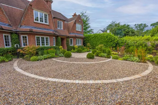 View from front of property shows large area using pebbles with Mint Sandstone cobble setts used to create circular patterns.