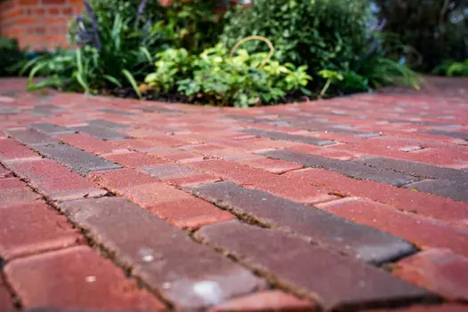 Ground-level view of Winton brick pavers, with planted bed beyond. Design by Georgia Lindsay. Built by Nordland Landscapes.
