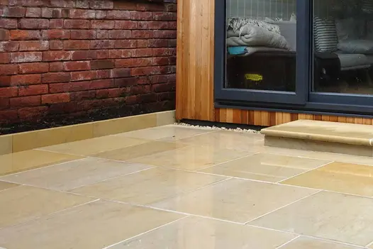 Harvest Edging Stones in a back garden, with matching paving and bullnose steps, creating a seamless transition to an outhouse.