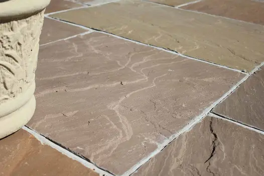 Detailed view of Raj Green Indian Sandstone paving shows off its natural riven texture and variations.