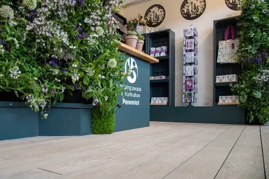 Limed Oak Millboard Decking floors Perennial charity stand, RHS Chelsea, with welcome desk, living wall and shelves of gifts.
