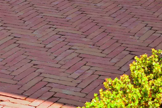 Close up of Roma dutch Clay pavers laid in herringbone style show off their red and yellow colours.