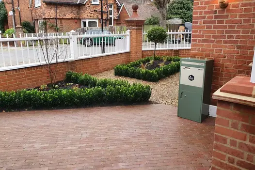 Wall with white railings borders front garden with 2 geometric beds, laid with gravel and Roma Clay Pavers. Built by AS Landscapes.