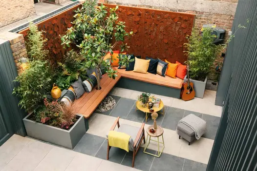 Walled courtyard paved in stripes of Slab Khaki and Slab Coke porcelain paving with a corner bench seat. Design by Georgia Lindsay.