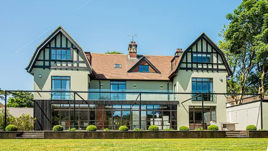 Arts and Crafts-style house with raised patio with retaining walls are faced with Steel Dark Designclad porcelain cladding.