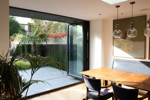 Steel Dark Luxury DesignClad feature wall photographed from inside the house through bi-fold doors leading to the garden.