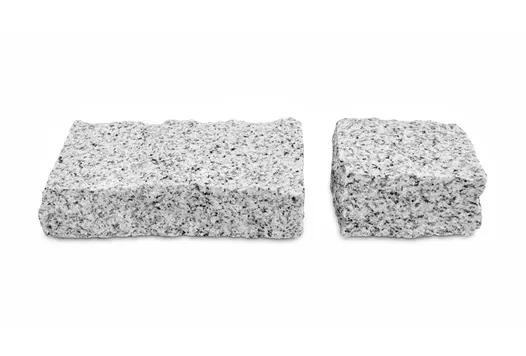 Two sizes of Silver Grey Granite Setts on a white background highlight the riven texture and colour of these cobblestones.