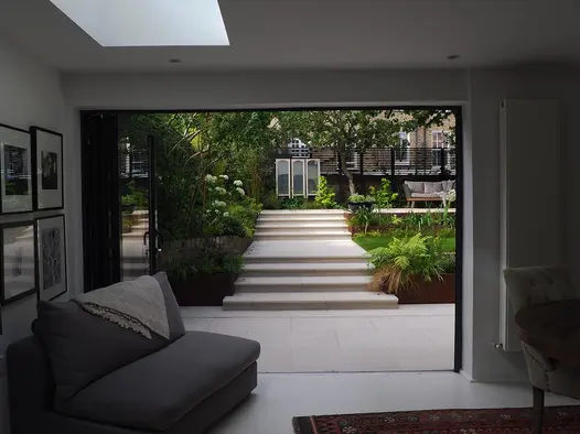 Interior space featuring porcelain patio, sliding doors, and Faro Porcelain 36mm Bullnose Steps leading to seating area.