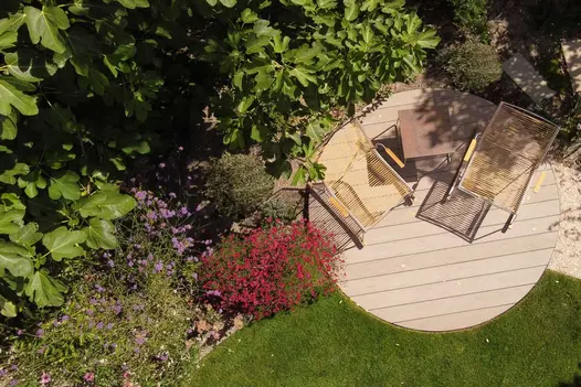 Chairs on Traditional DesignBoard round composite deck straddling border between lawn and border. Design by Jaki Grosvenor.