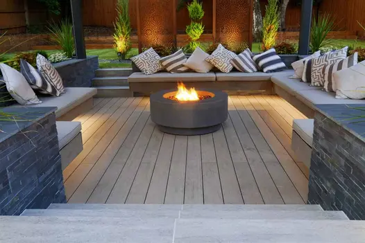 Porcelain steps down to sunken pergola-covered seating area with cantilevered benches and Traditional Designboard WPC decking.