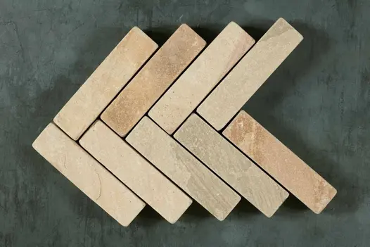 9 Tumbled Mint sandstone pavers, arranged in a herringbone pattern with 5 courses of 2 patio bricks each.
