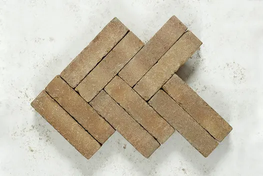 10 buff Westminster Brick pavers laid on edge in double herringbone pattern on grey background. Free UK delivery available.